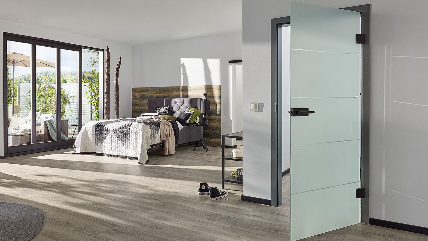 Ein modern eingerichtetes Schlafzimmer mit einer hochwertigen Glastür der Marke HQ