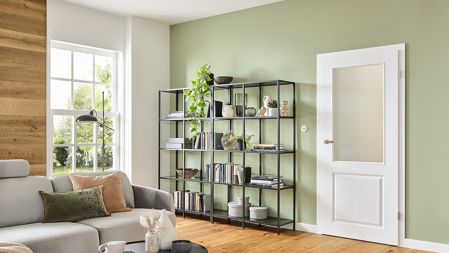 Ein gemütliches Wohnzimmer im Landhausstil mit einer opal weißen Zimmertür mit Glaseinsatz
