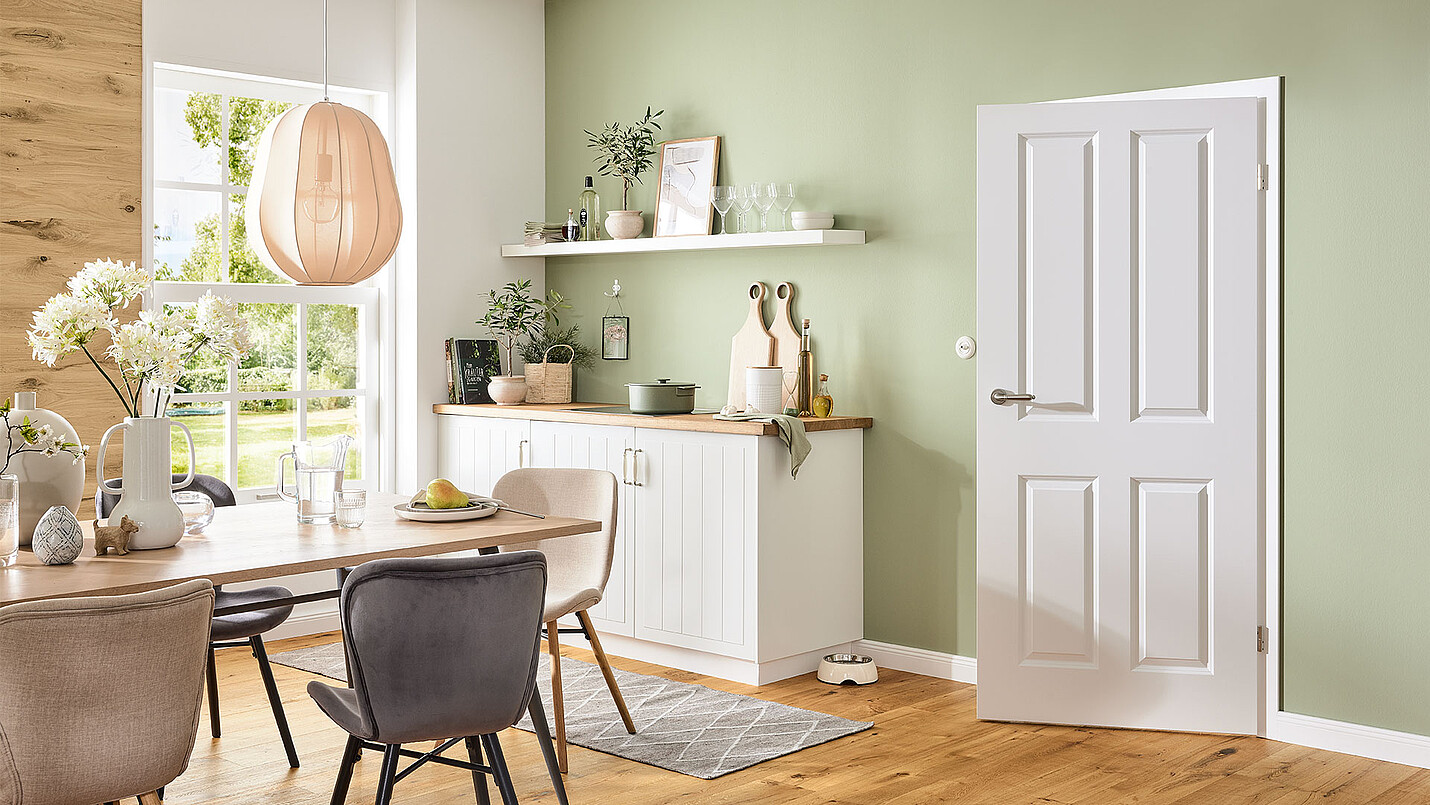 Eine gemütliche Küche im Landhausstil mit einer weißen HQ Zimmertür und einem Landhausdielenboden